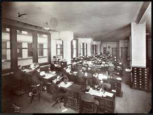 Män och en kvinna som arbetar vid skrivbord på ett kontor på Metropolitan Life Insurance Co. på 23rd Street och Madison Avenue, New York, 1907 (silvergelatintryck)